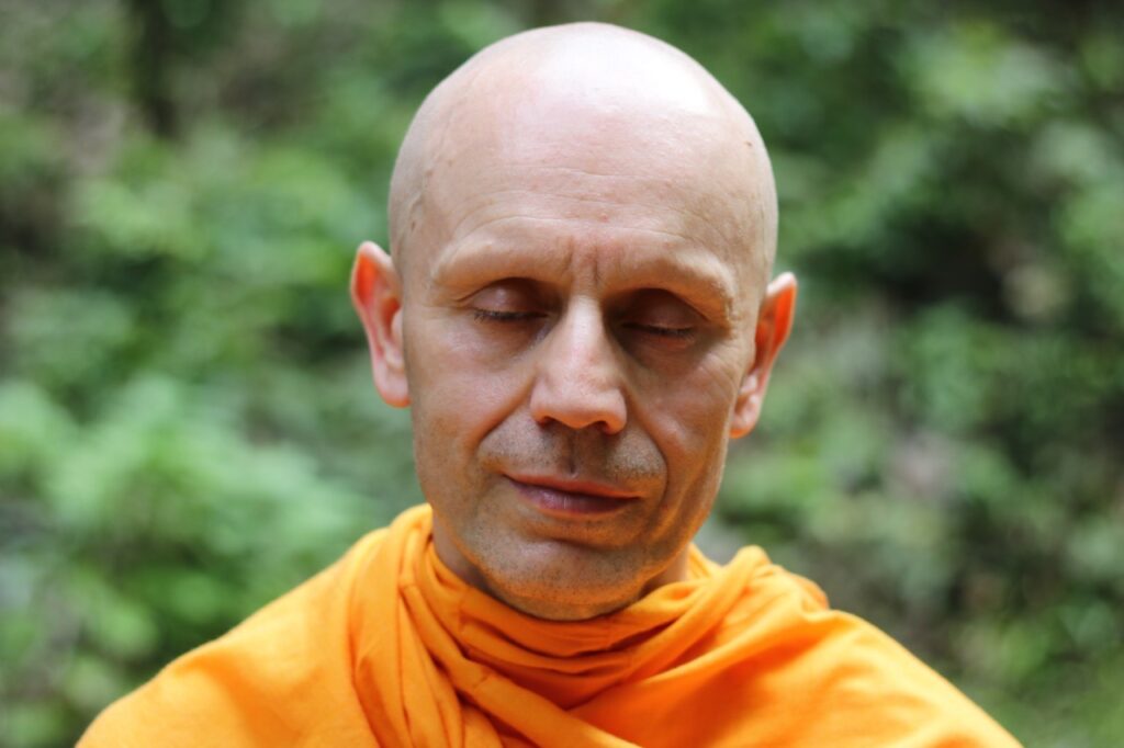 Medytująca osoba siedząca w pozycji lotosu, symbolizująca harmonię i duchową równowagę Szlachetnej Ośmiorakiej Ścieżki w buddyzmie.